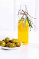 Foto gratuita olio d'oliva in una bottiglia con olive