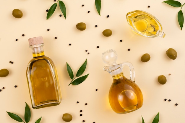 Olive oil in bottles and cup on table