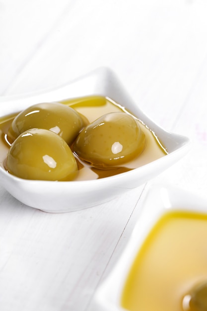 Olive oil in bowl with olives