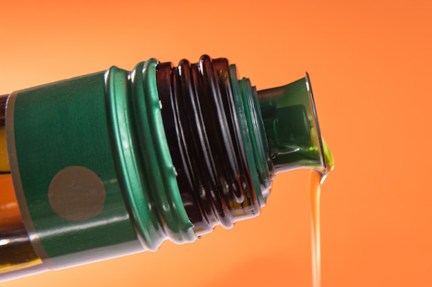 Free photo olive oil container over orange background