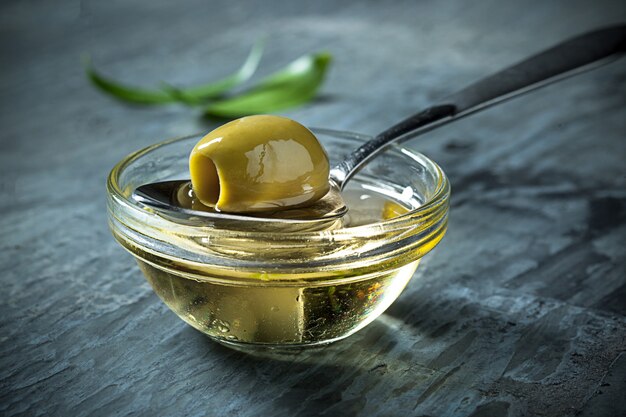 Olive oil and olive branch on the wooden table