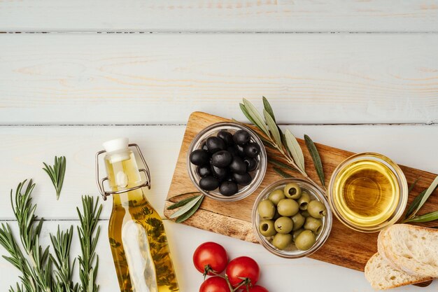 Olive oil olives and tomatoes on wooden background