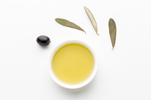 Free photo olive oil saucer with leaves and black olive