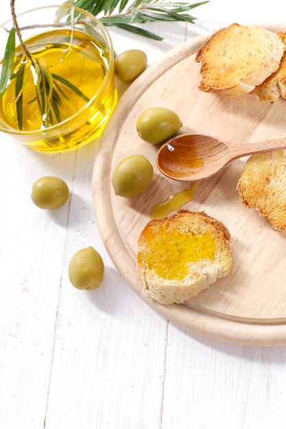 Olive oil with bread and wooden spoon