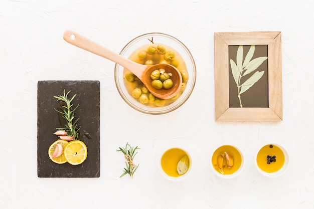 Olive oils with twig wooden frame on white background