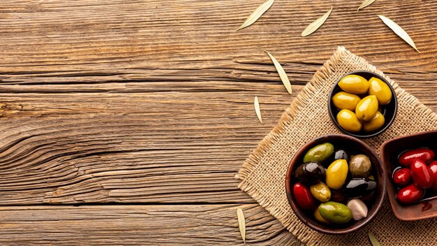 Olives in bowls on textile material with copy space