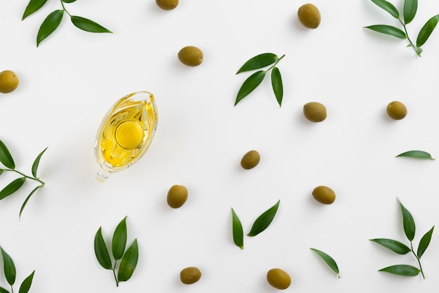 Olives and lives on table with oil in cup