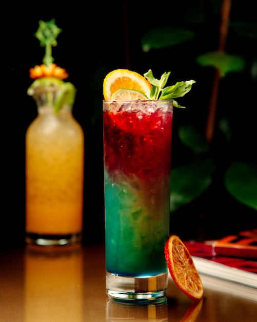 Free photo ombre cocktail garnished with orange and lime slices