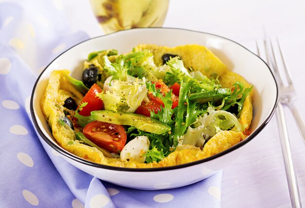 Omelet with fresh tomatoes, black olive, avocado and mozzarella cheese. 