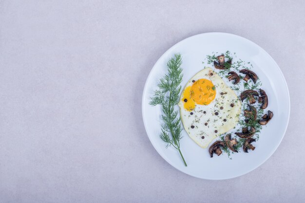 Omelet with fried mushrooms on white plate .