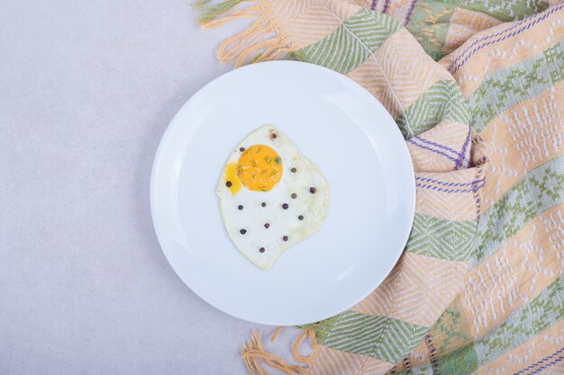 Omelet with pepper on white plate .
