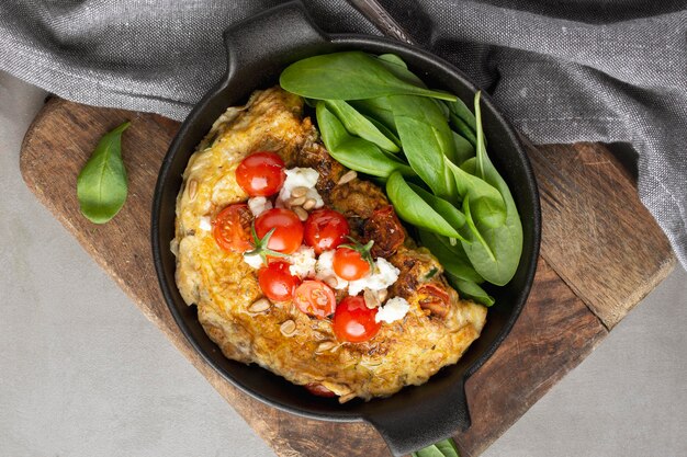 Omelette with cheese and tomatoes on cutting board