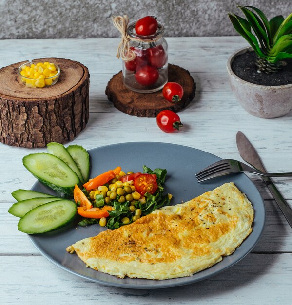 오이, 토마토, 옥수수와 소박한 스타일의 허브 샐러드와 오믈렛