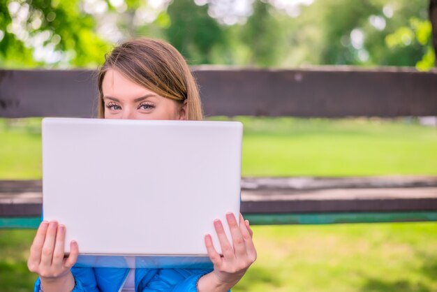 omputer and fresh air. Woman hiding face behind laptop monitor