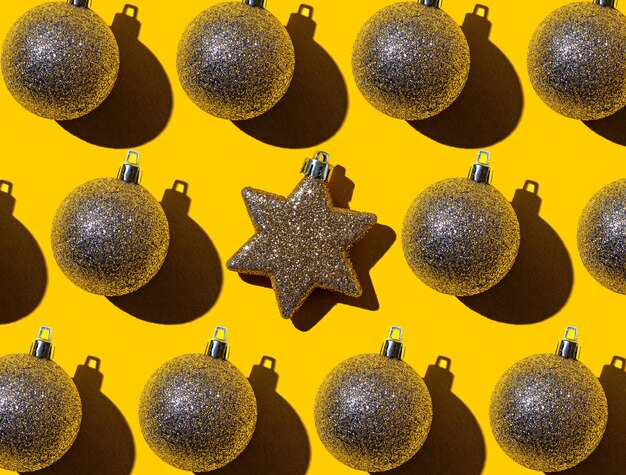 明るい​黄色​の​背景​に​は​、​中央​に​金色​の​星​が​付いた​正月​の​金色​の​ボール​の​パターン​が​あります​。​クリスマス​と​年末年始​の​背景
