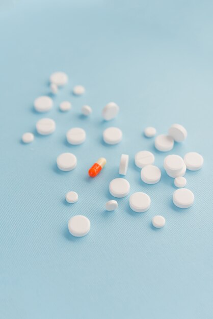 One capsule surrounded by white tablets