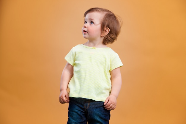 One cute baby girl on orange background