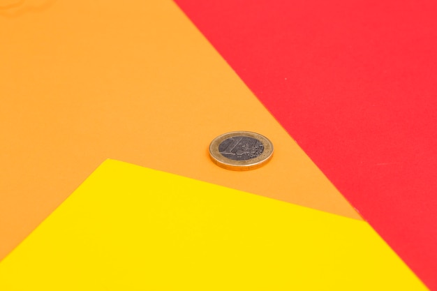 赤い1ユーロのコイン。黄色とオレンジ色の背景