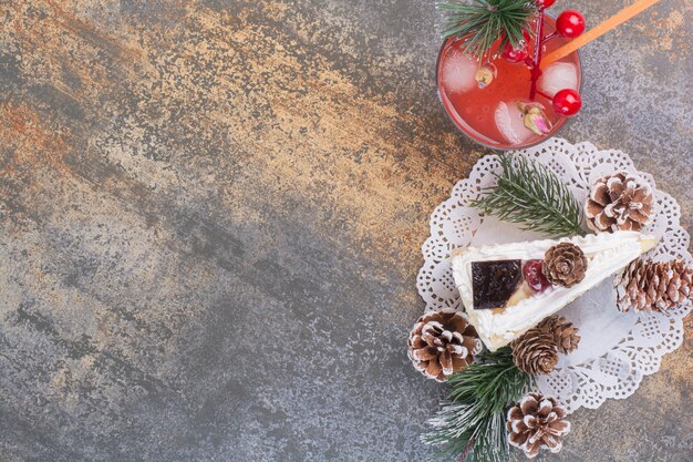 One piece of cake with pinecones and cold strawberry juice with straw. 