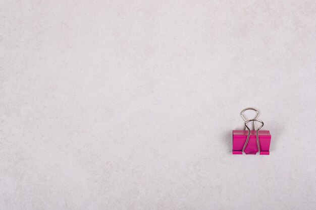 One pink paper clip on white background