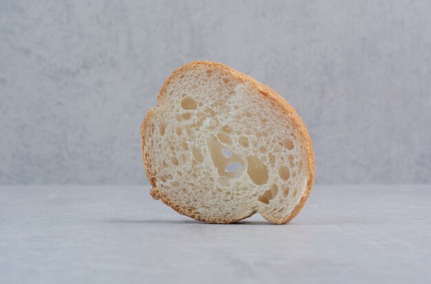 대리석 바탕에 둥근 신선한 흰 빵 한 조각.