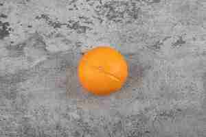 Бесплатное фото Один весь свежий здоровый апельсиновый фрукт на каменном столе.