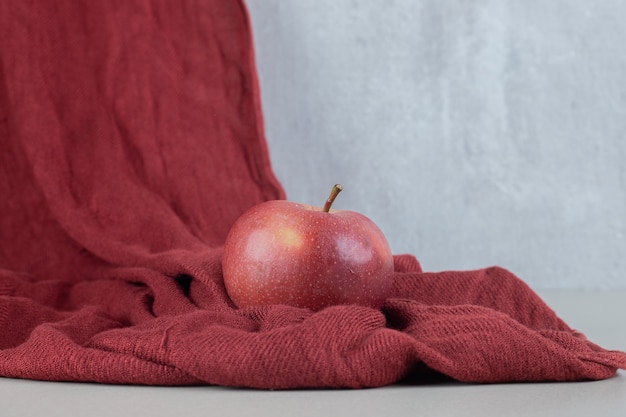 布の上に丸ごと赤い新鮮なリンゴ1個。