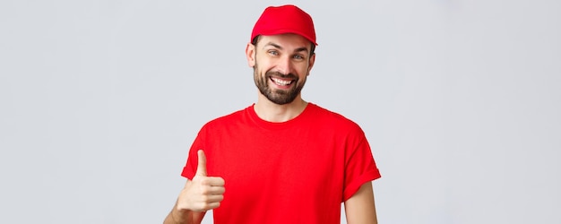 Доставка онлайн-покупок во время карантина и концепция еды на вынос Дружелюбный веселый курьер в красной кепке и футболке поощряет делать интернет-заказы, одобряя или рекомендуя