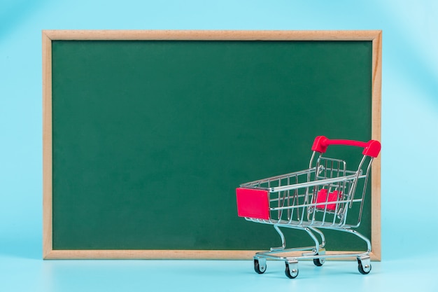 Online shopping , a double cart placed on a green board on a blue  .