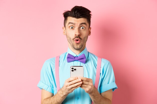 Интернет-магазины заинтриговали парня в галстуке-бабочке, просматривая промо-предложение в Интернете по мобильному телефону, и скажите: "Вау на ..."