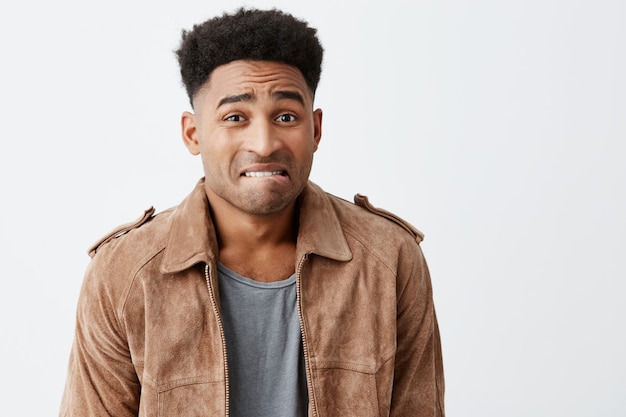 Oops. Portrait of unhappy young good-looking afro american men with curly hair in casual stylish clothes looking at mother with guilty face expression after breaking her favorite vase.