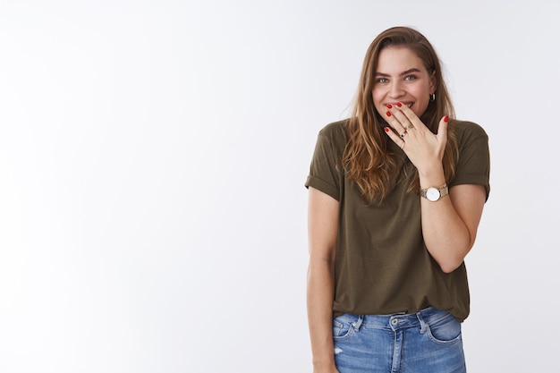 Oopsie, maybe it was me. Cute silly attractive funny woman mocking friend covering mouth smiling hiding giggle, chuckling after prank standing amused delighted shrugging white background