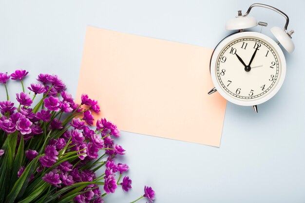 Op view flowers with card and clock beside