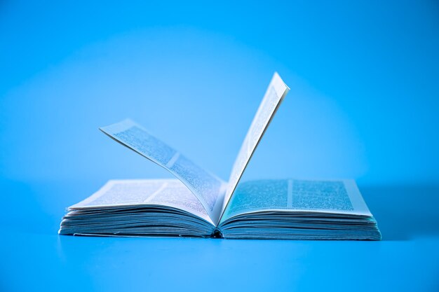 Открытая книга на синем фоне изолированных крупным планом