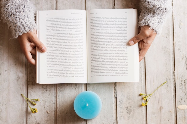Open book and blue candle from top view