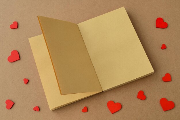Open book or notebook made of kraft paper, red hearts on table. valentines day, valentine card, love