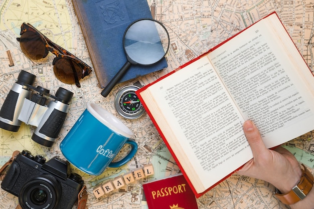 Free photo open book surrounded by travel elements