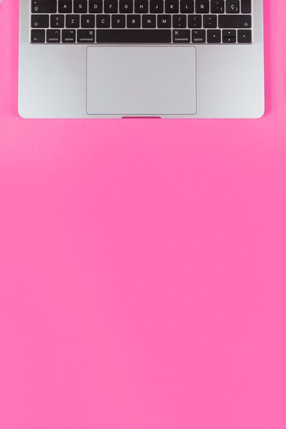 An open laptop over pink background with copy space for text