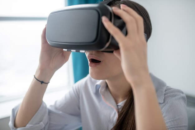 Open-mouthed young woman playing a 3D game