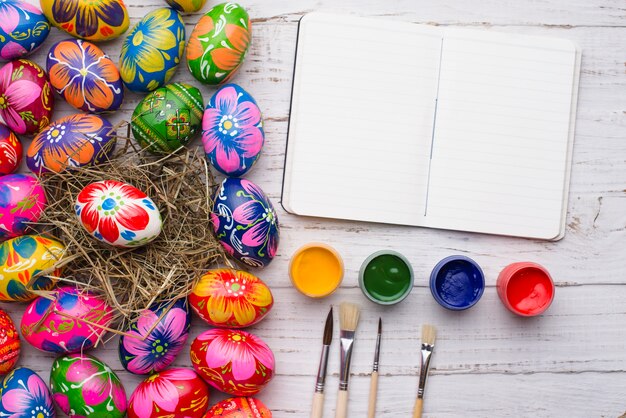 Open notebook with paint jars and easter eggs