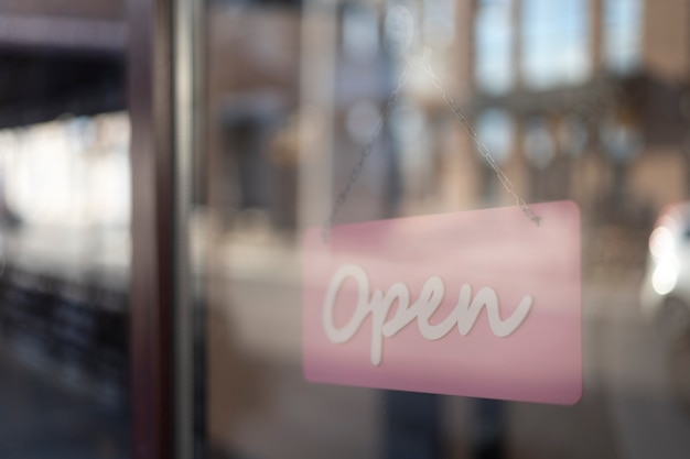 Open pink sign behind window