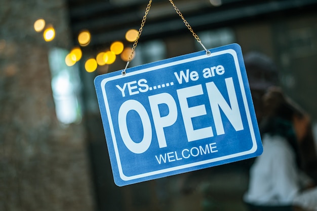 open sign broad through the glass of window at coffee shop