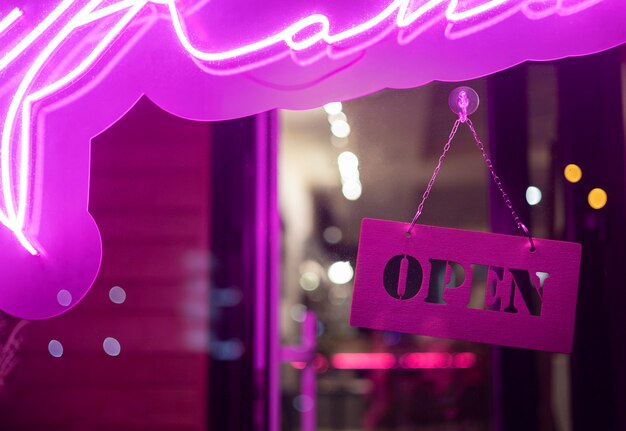 Open sign hanging with purple light