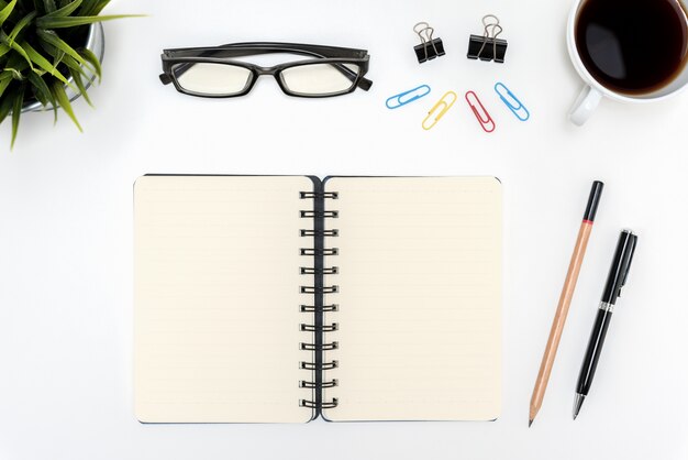 Open spiral blank notebook on white desk table