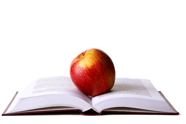 Открытая студенческая книга с красным яблоком