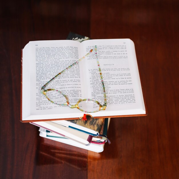 Opened book and glasses on table