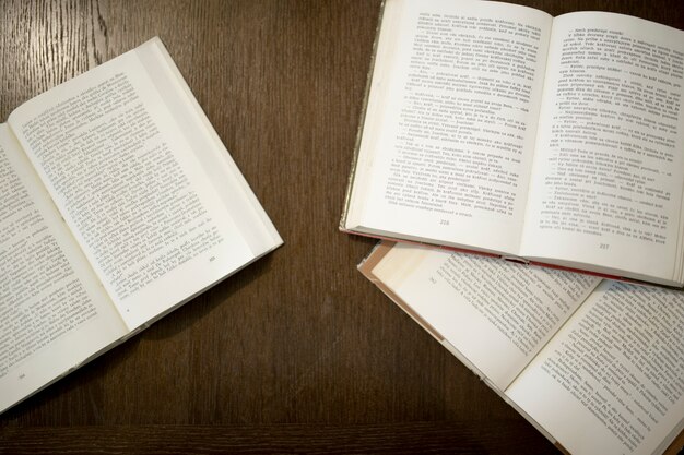 Opened books on wooden background