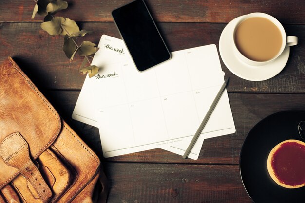 Opened craft paper envelope , autumn leaves and coffee on wooden table