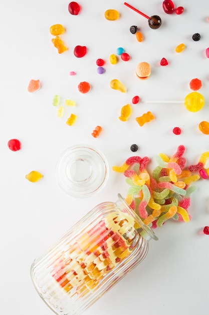 Free photo opened jar near spilled sweets