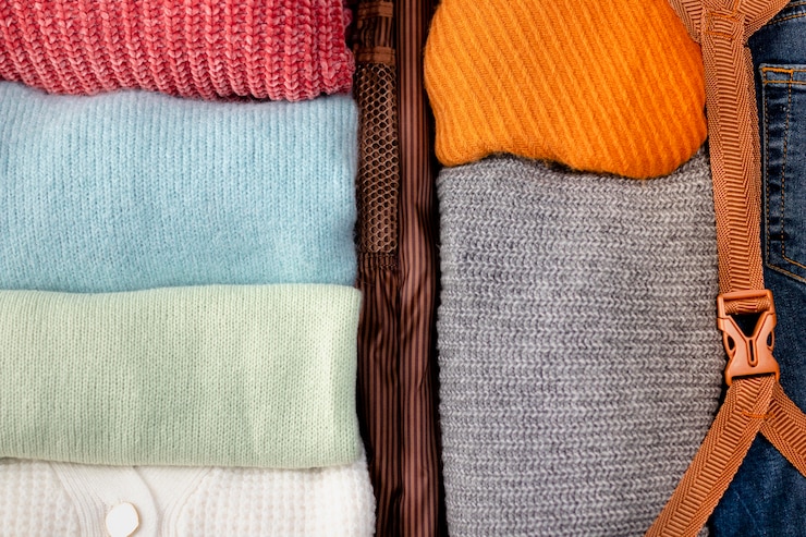 Free Photo opened luggage with folded clothes close up